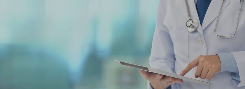 Przycięte zdjęcie lekarza w białym fartuchu pokazującego palcem na tablet